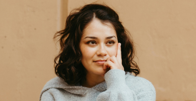 A person smiling thoughfully - their gaze is slightly off centre.