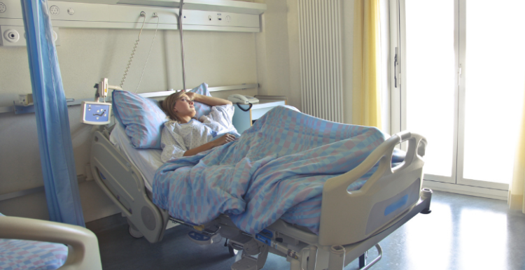 Photo of a person laying in a hospital bed looking out of the window