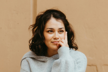 A person smiling thoughfully - their gaze is slightly off centre.