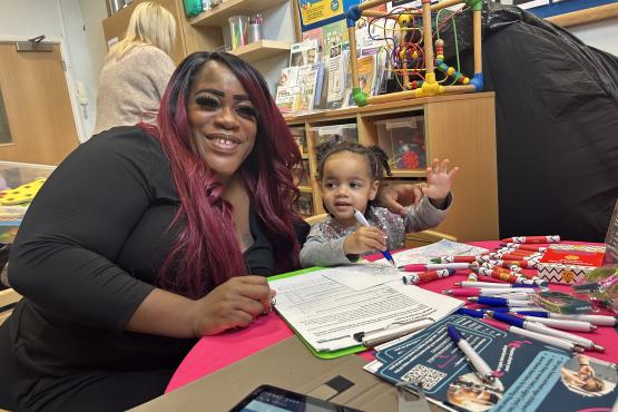 A mother and child sitting at our Healthwatch table at one of our engagement events