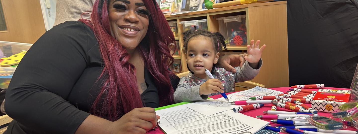 A mother and child sitting at our Healthwatch table at one of our engagement events