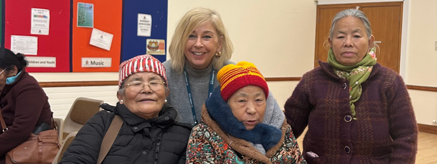 Photo of 3 Nepali women with one of our Insight and Engagement Officers - they are in a community hall.