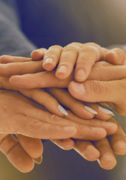 Several hands coming together - placed on top of each other