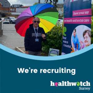 Photo of a person holding a brightly coloured umbrella. They are standing outside beside a Healthwatch Surrey banner. Under the photo are the words 'We're recruiting' and the Healthwatch Surrey logo