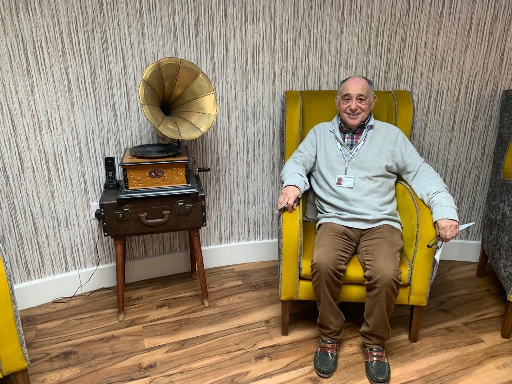 Errol sitting in a chair beside a gramophone at one of the Enter and View visits
